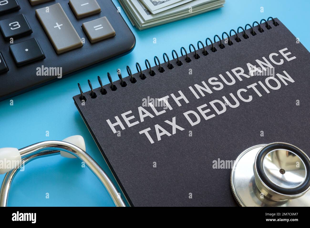 Health insurance tax deduction inscription, stethoscope and calculator. Stock Photo