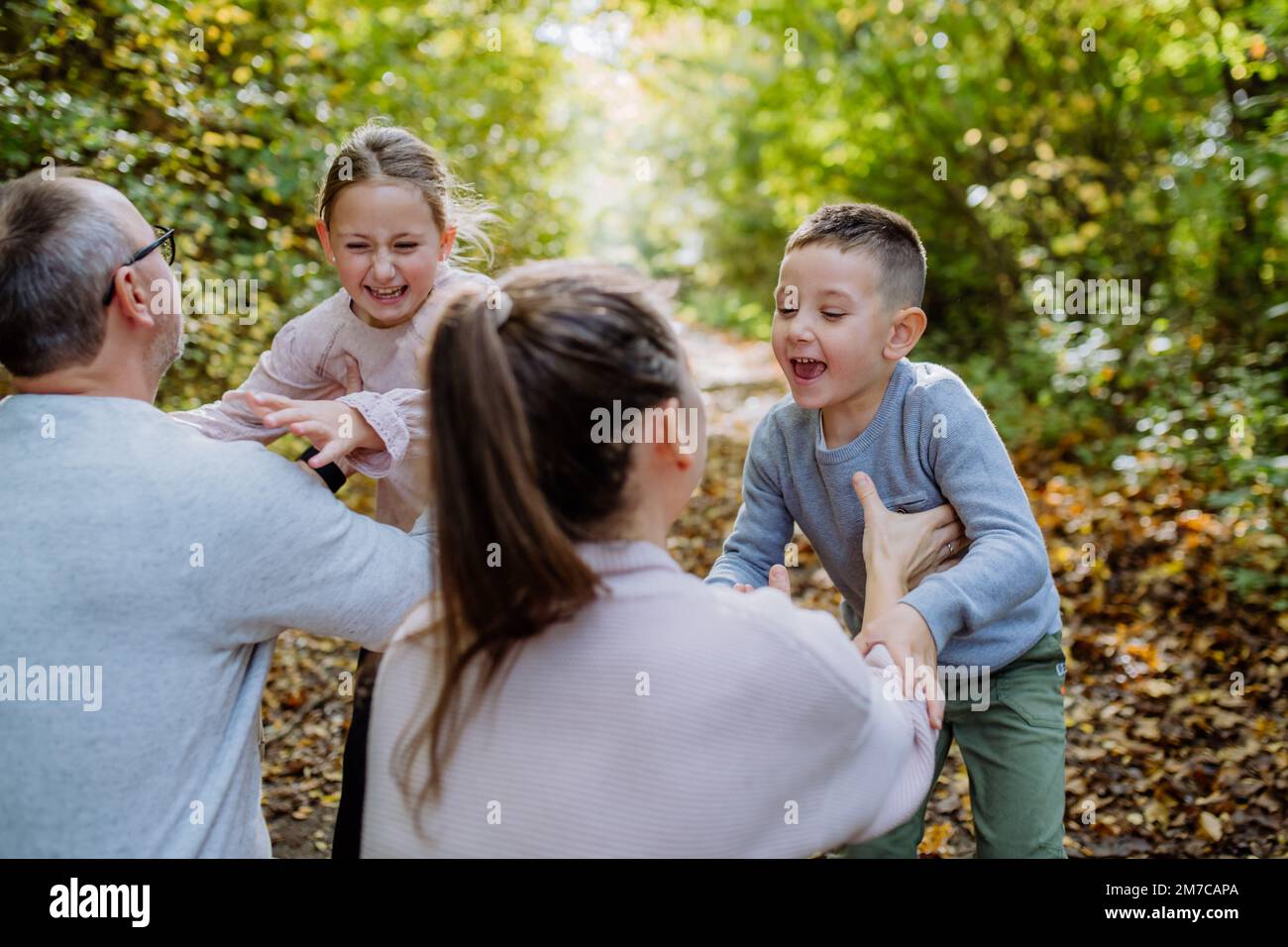 Parents with their little children having fun in forest Stock Photo - Alamy