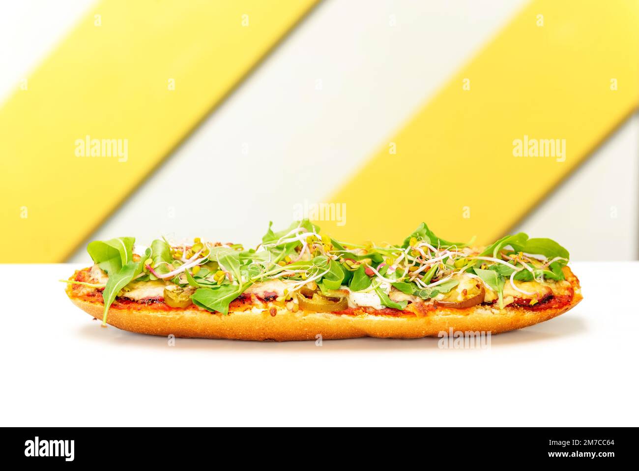 baguette with tomato sauce, meat, jalapeno and arugula baked with cheese. popular street fast food Stock Photo