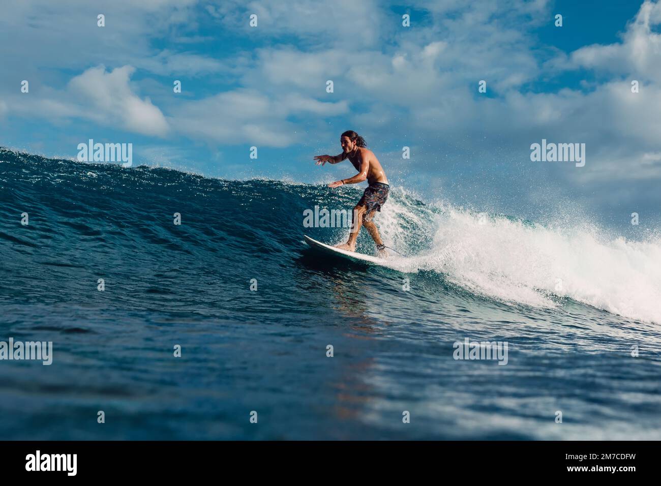January 4, 2023. Bali, Indonesia. Man in tropical ocean during surfing.  Surfer ride on surfboard on blue wave Stock Photo - Alamy