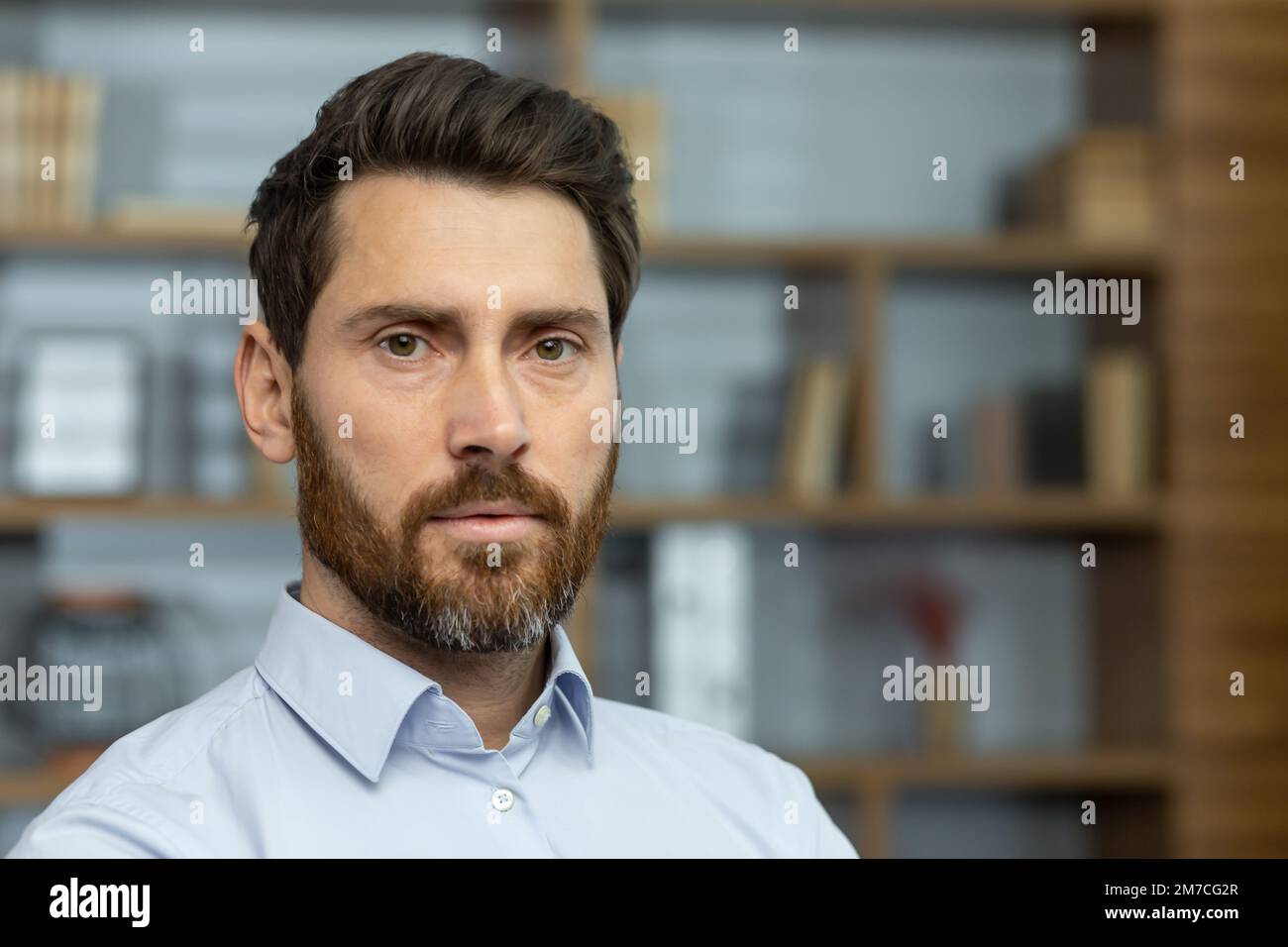 Close up photo of serious boss in shirt in home office, mature man with beard looking at camera thinking, businessman investor headshot. Stock Photo