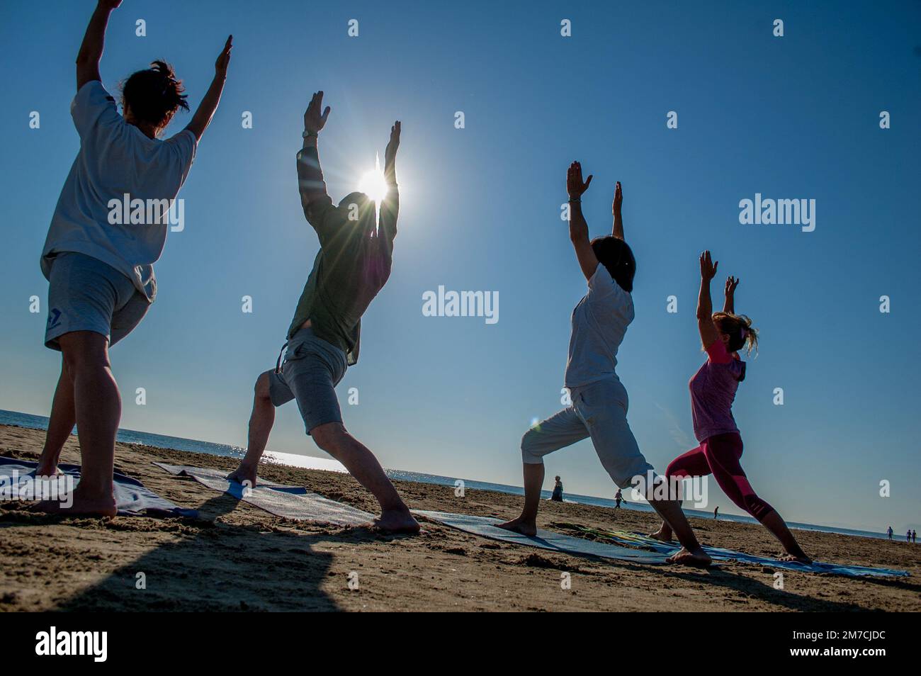 Rimini Italy August 7 2016: Group of people doing gymnastics at sunrise on the beach Stock Photo