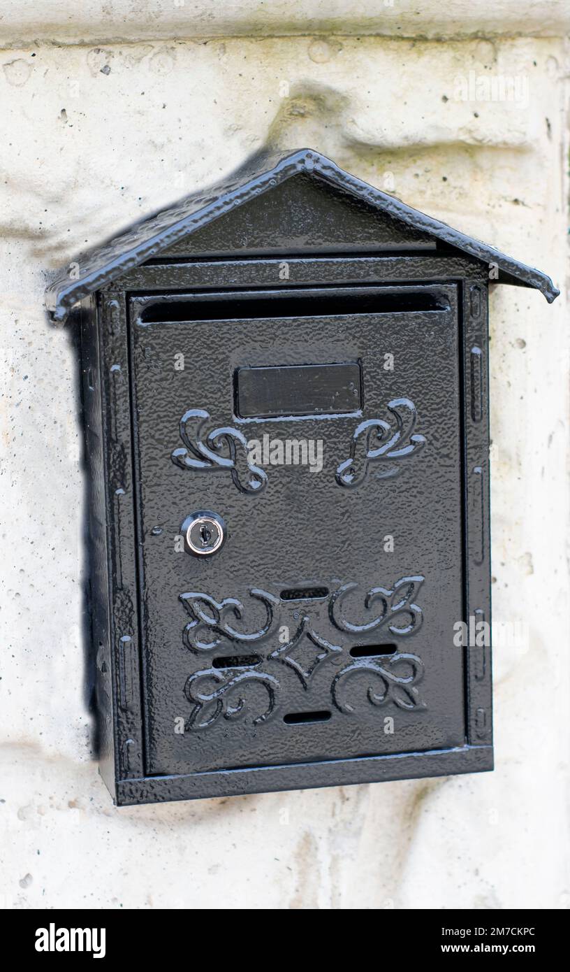 Black mailbox placed on the wall. Stock Photo