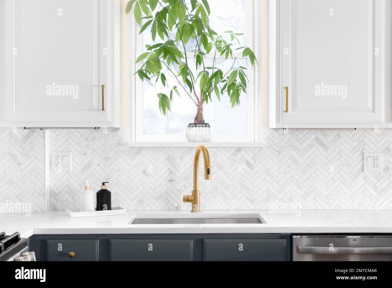 Sink detail shot in a luxury kitchen with herringbone backsplash tiles