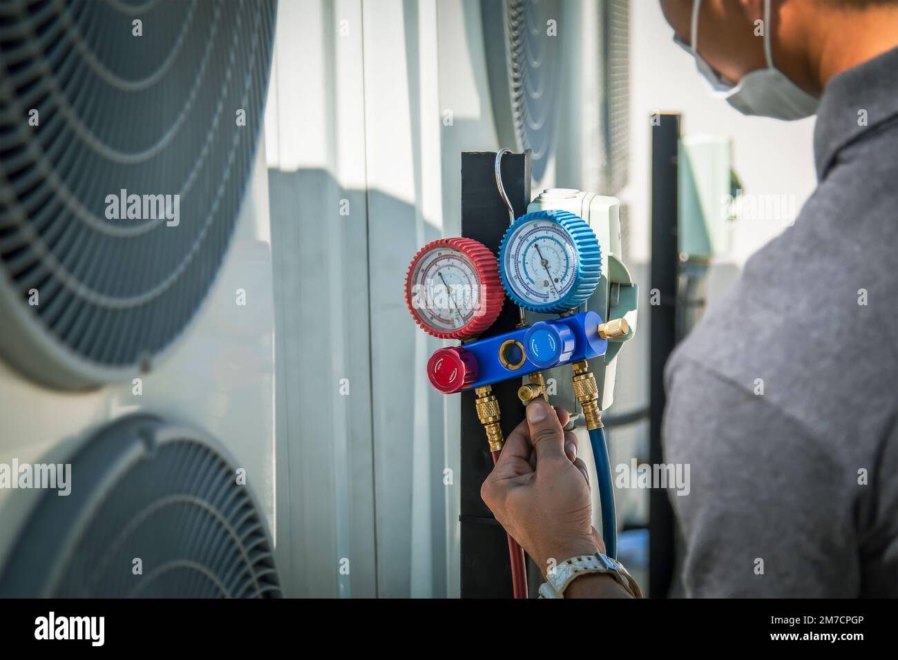 Air conditioner technician checking air conditioner operation Stock