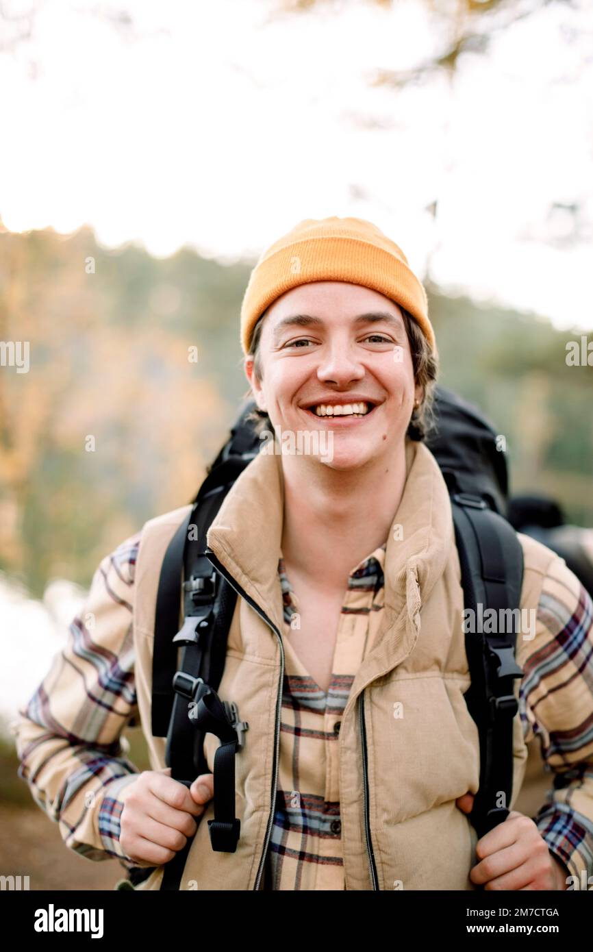 Portrait of happy young man wearing knit hat during hiking Stock Photo