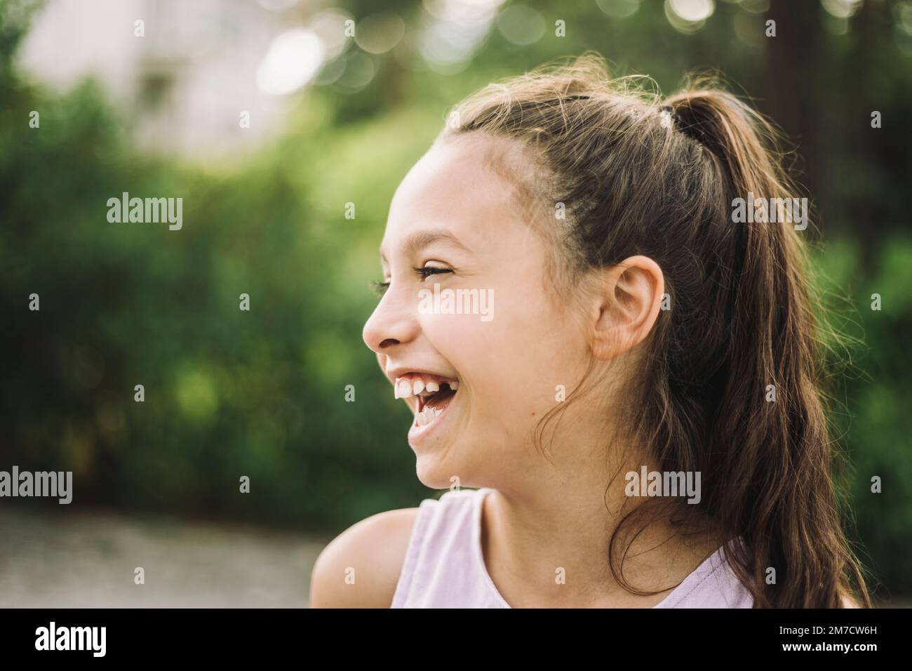 Cheerful girl looking away and laughing Stock Photo