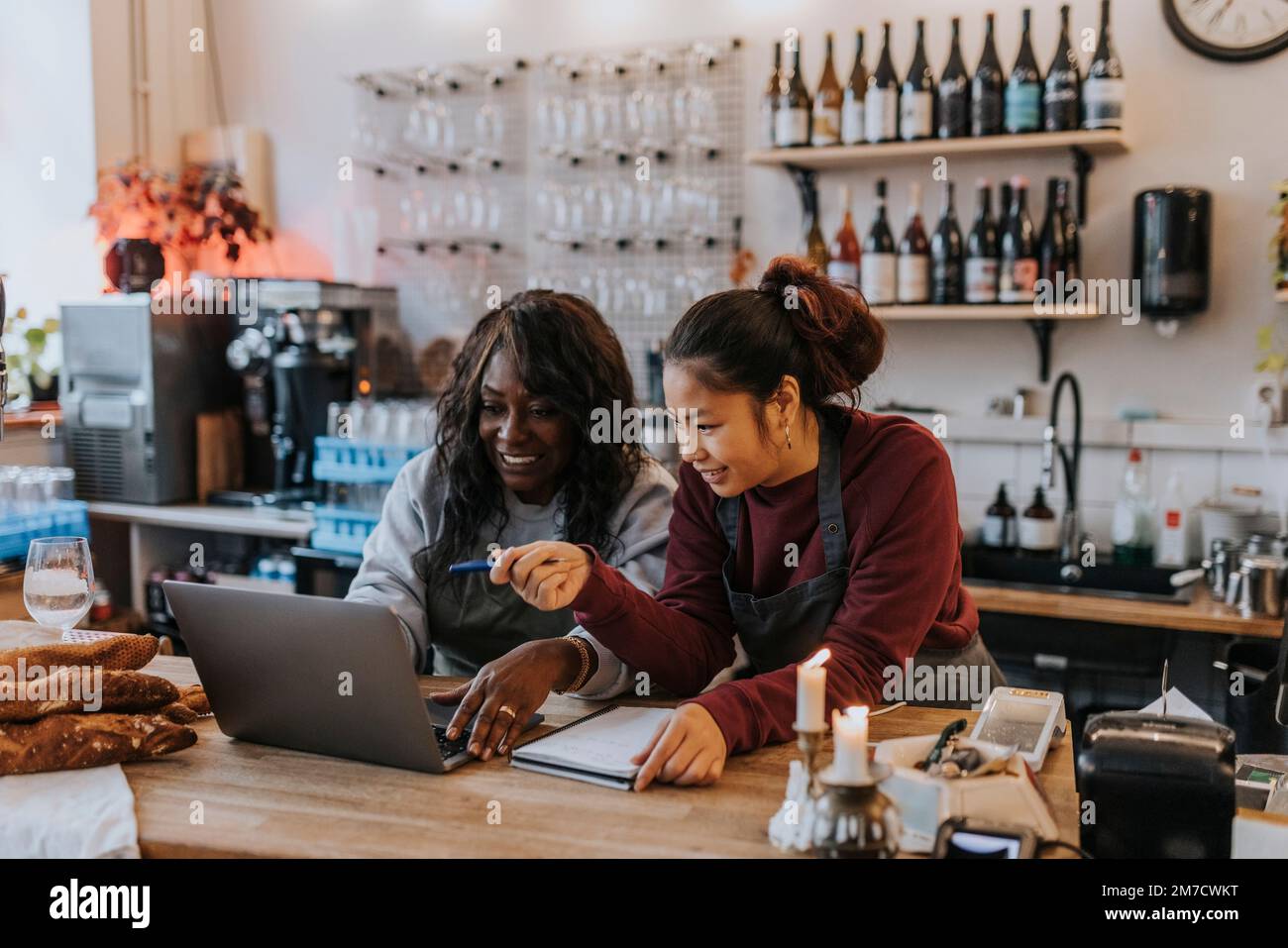 Female entrepreneurs discussing over laptop in coffee shop Stock Photo