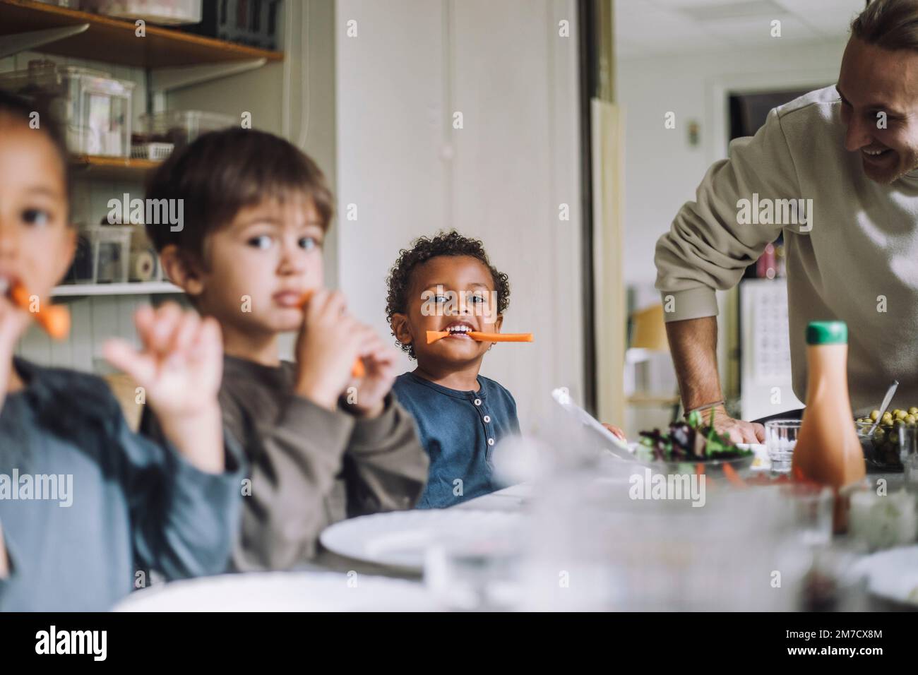 Multiracial male and female students eating carrots for breakfast in