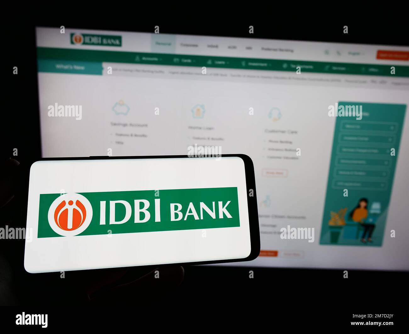 Person holding smartphone with logo of Indian financial company IDBI Bank Limited on screen in front of website. Focus on phone display. Stock Photo