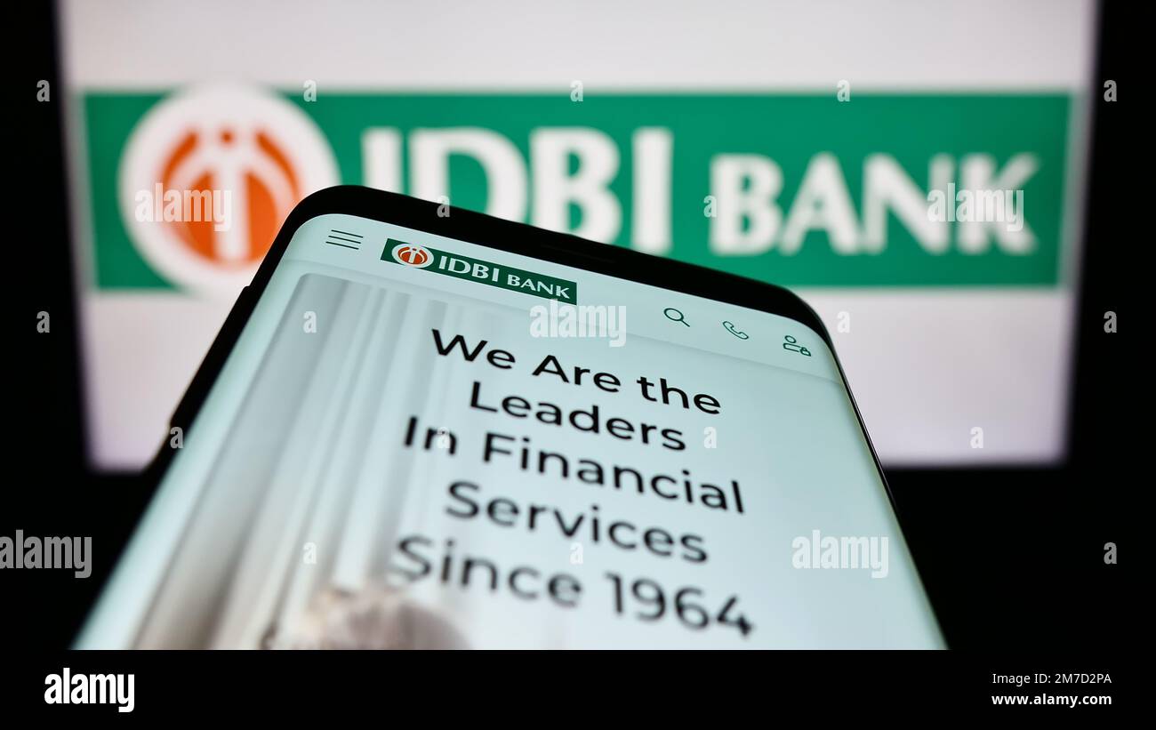 Mobile phone with website of Indian financial company IDBI Bank Limited on screen in front of business logo. Focus on top-left of phone display. Stock Photo