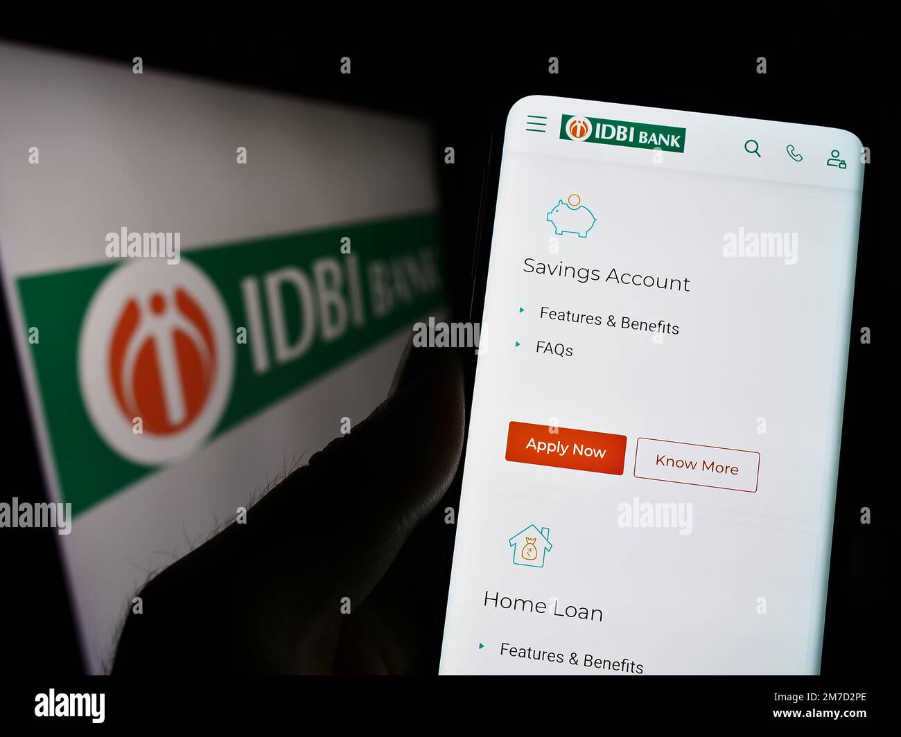 Person holding cellphone with webpage of Indian financial company IDBI Bank Limited on screen in front of logo. Focus on center of phone display. Stock Photo