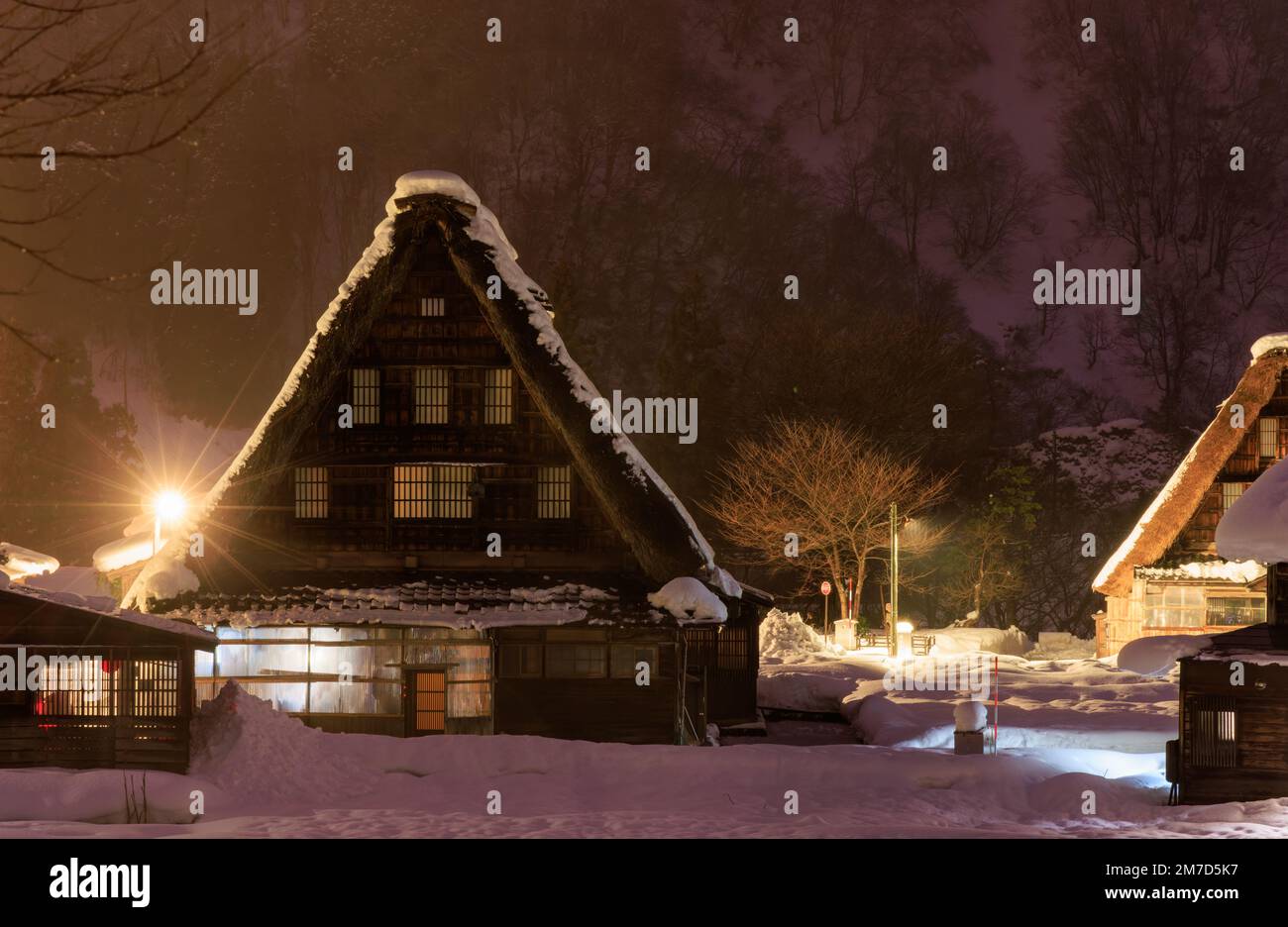 Traditional A-frame house in Gokayama amid snow and mist at night Stock Photo
