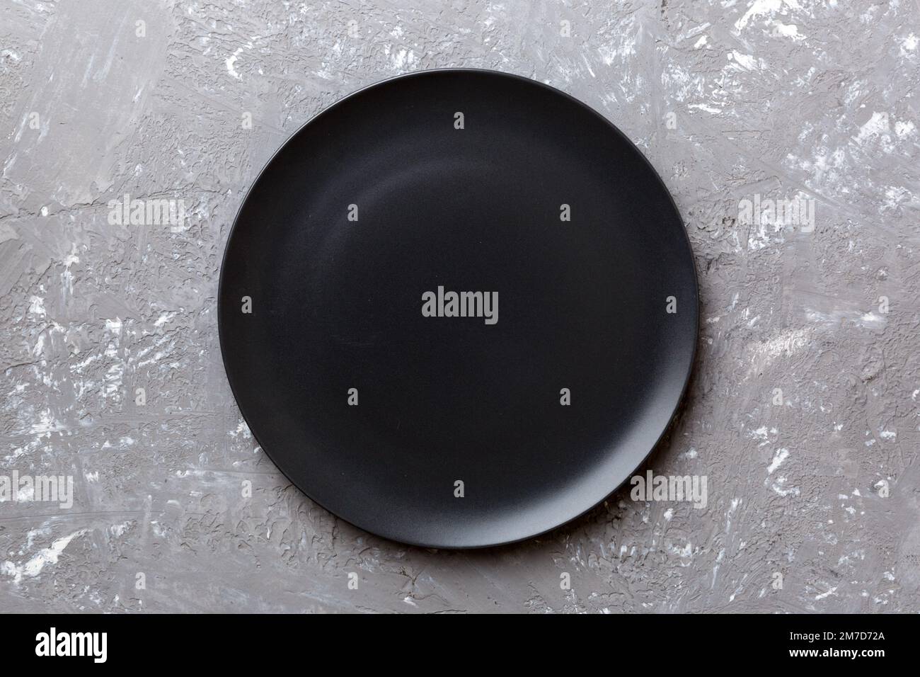 Top view of black plate on cement background. Empty space for your ...