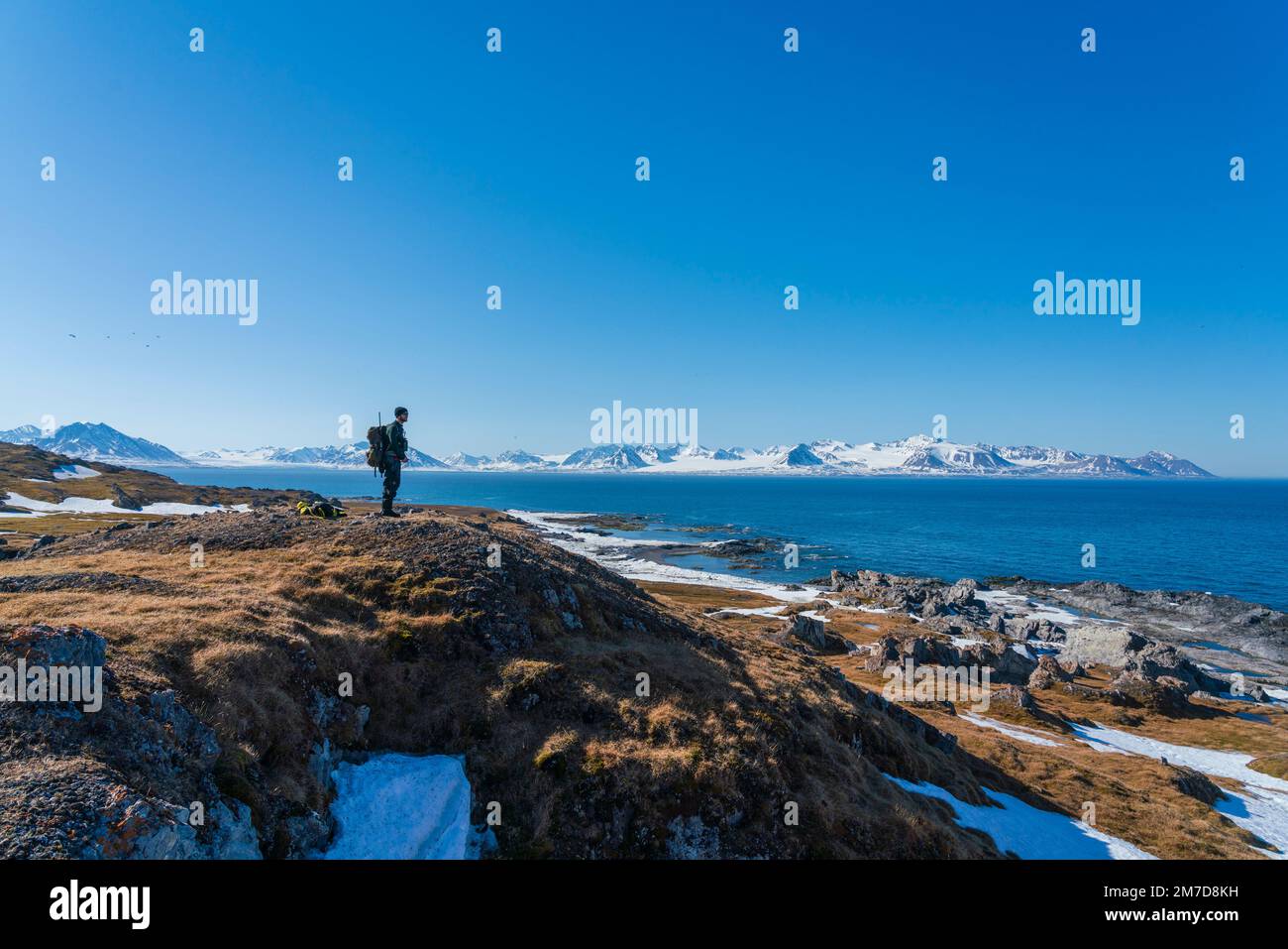 An arctic guide checking the area for Polar bears,  Gasbergkilen, Spitsbergen, Svalbard Islands, Norway. Stock Photo