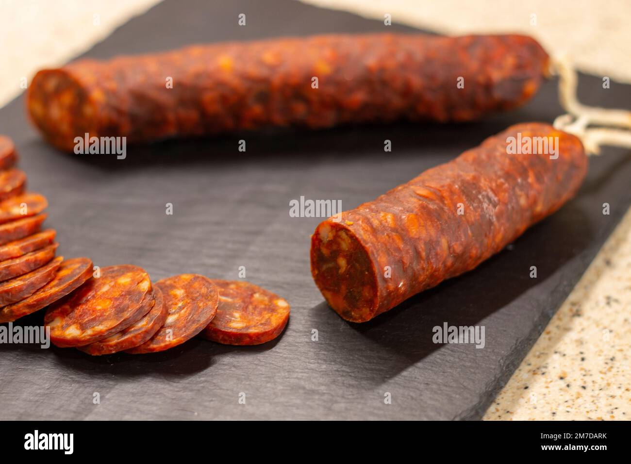 Authentic chorizo from León cut into thin slices, presented on a slate