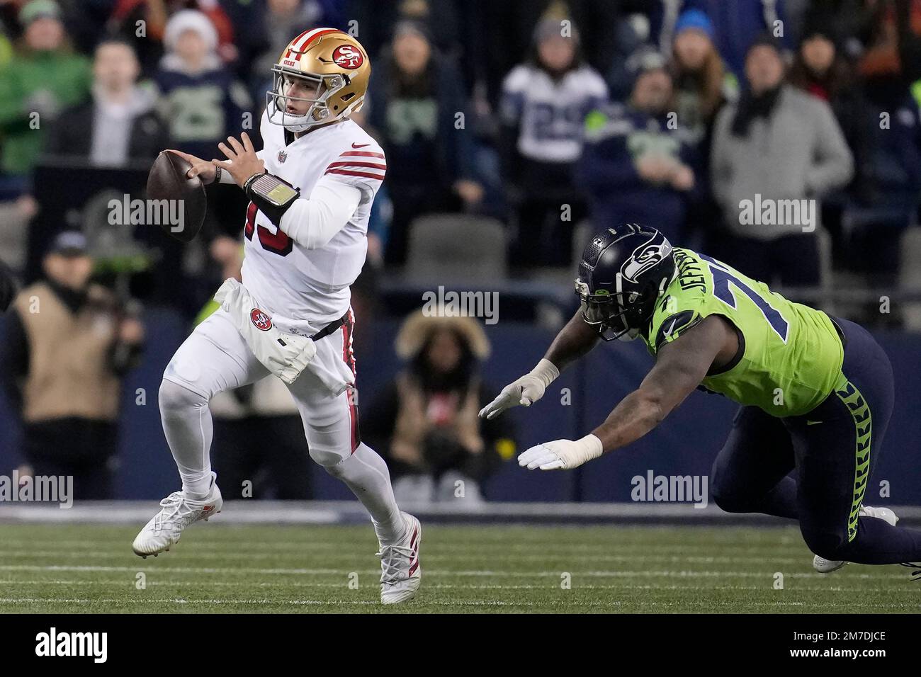 San Francisco 49ers quarterback Brock Purdy runs against Seattle Seahawks  defensive tackle Quinton Jefferson during the second half of an NFL  football game in Seattle, Thursday, Dec. 15, 2022. (AP Photo/Marcio Jose