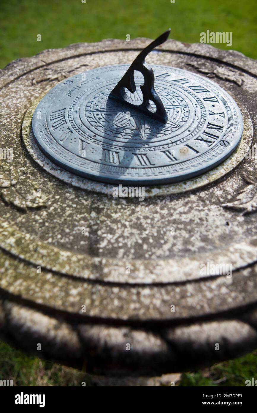 A sundial shows the time passing in agrden in the UK as the sun casts the shadow across its face