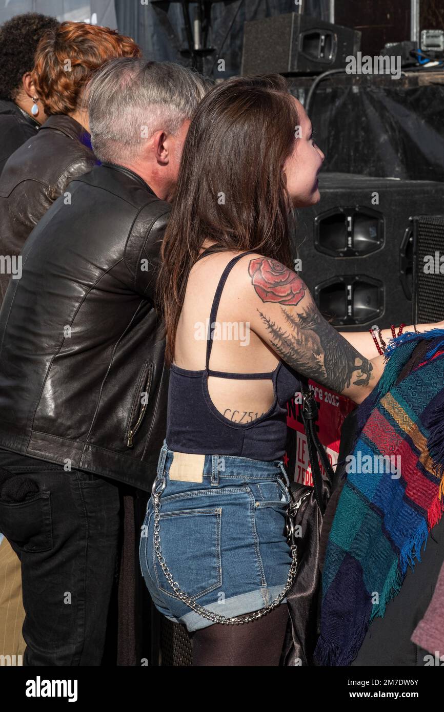 Young woman in jean shorts with tattoos on her arm and metal chain hanging from his jean shorts Stock Photo