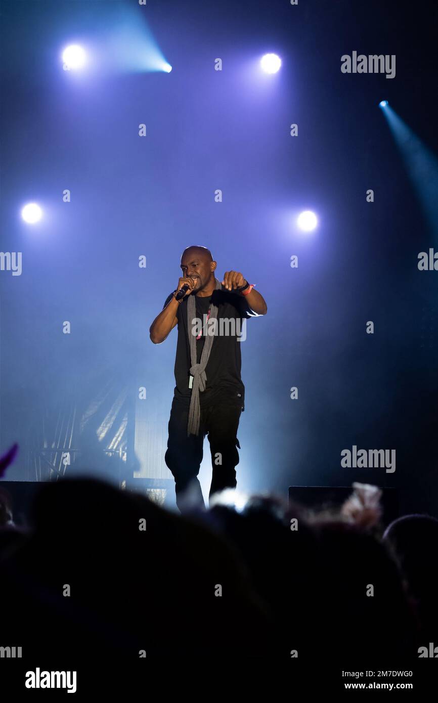 rapper on stage with white lights in the background Stock Photo