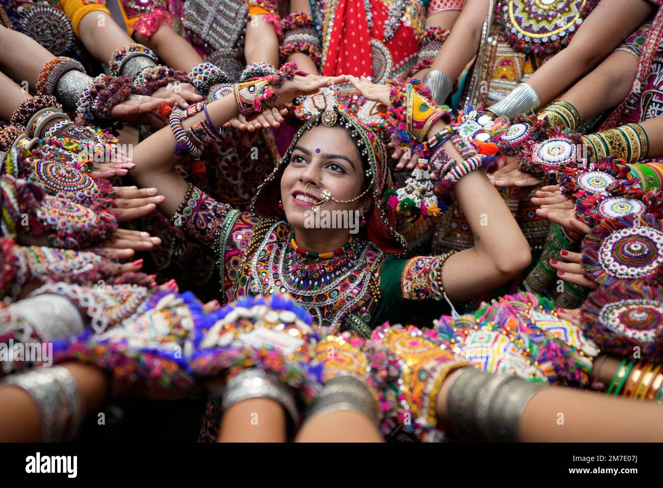 Women wearing traditional attire pose for photographs as they practice