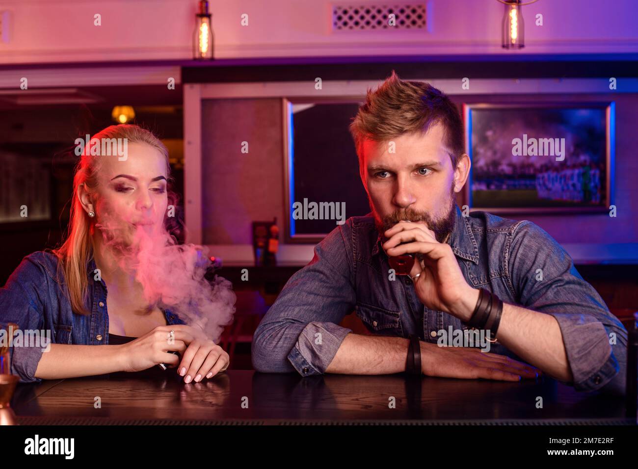 A man and woman smoking electronic cigarette in a vape bar Stock Photo ...