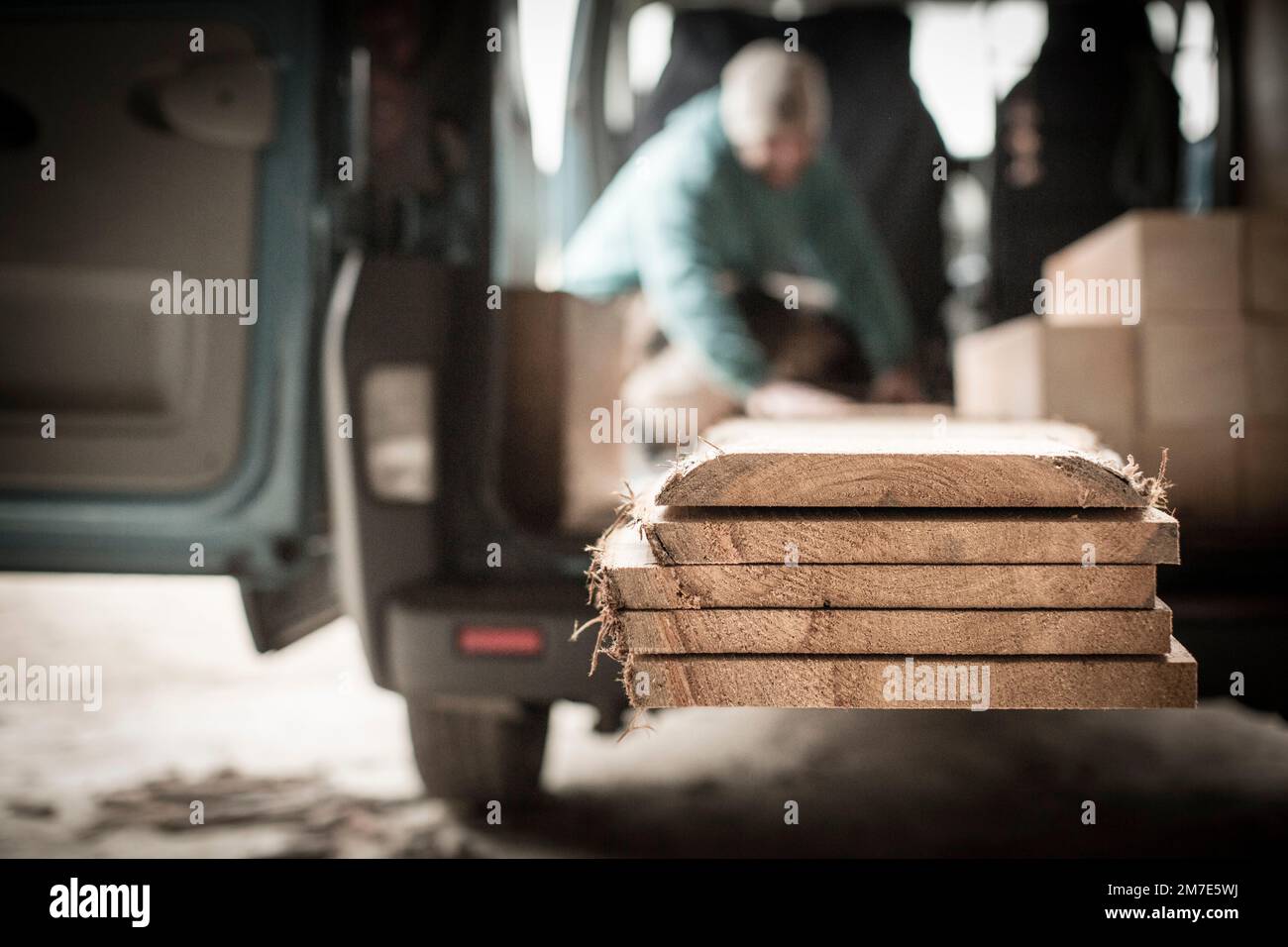 A furniture maker and joiner in his with wooden planks and