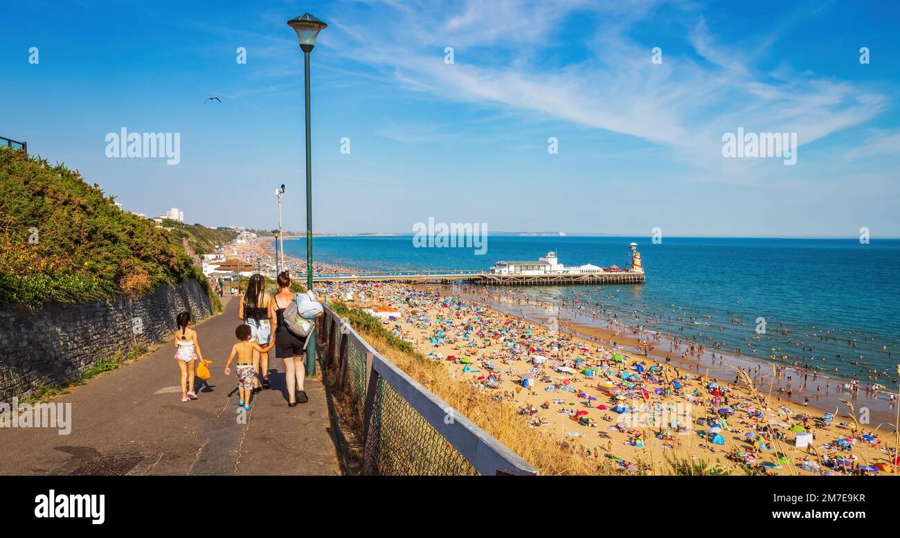 View of Bournemouth beach and Pier in Bournemouth Dorset UK during sunset. full beach during summer. people taking sunbathe. crowded beach Stock Photo