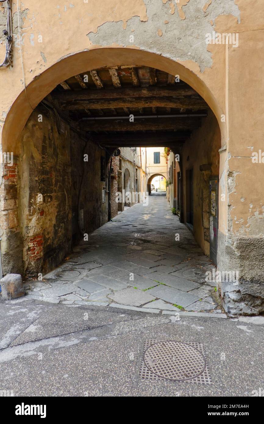Passageway, ingresso, through and under old buildings in the historic old town, within the walls, of Lucca, Tuscany, Italy. Stock Photo