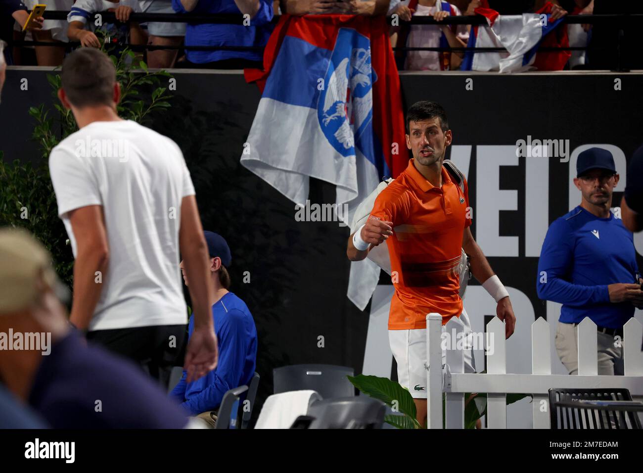 Serbias Novak Djokovic speaks to his coaches as he heads to the locker room after winning the 2nd set against USAs Sebastian Korda during the final of the Adelaide International tennis tournament