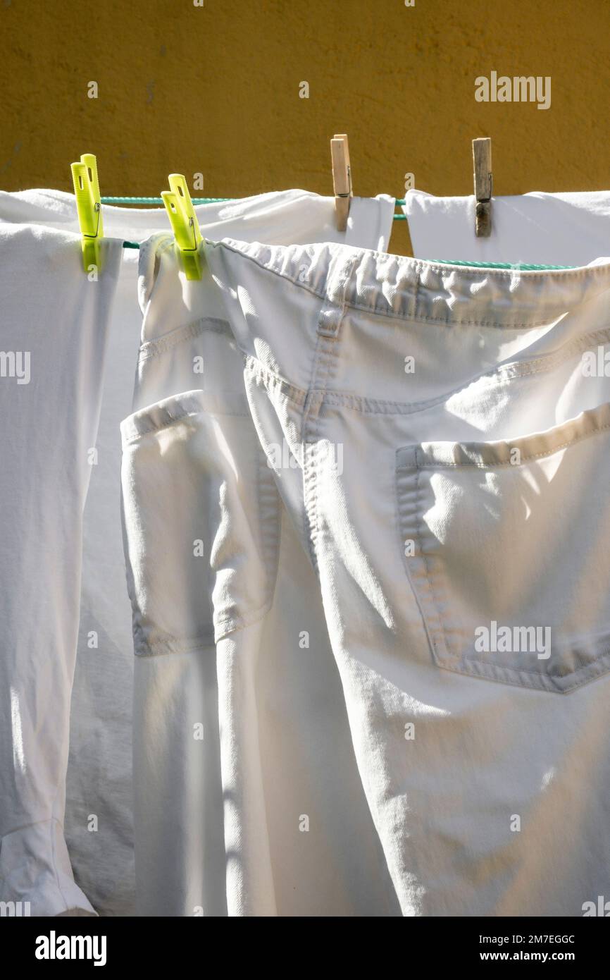 Man hanging washing on clothes line with pegs in the garden Britain, Uk.  domesticated male drying outside exterior household chores jobs work men  Stock Photo - Alamy