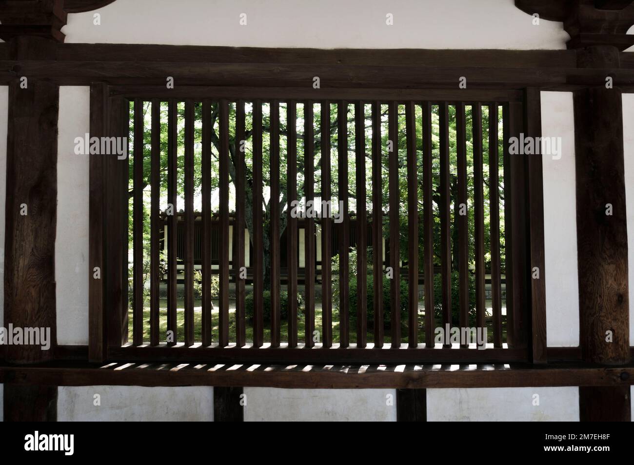 Traditional asian wooden bars on a window with greenery behind it Stock ...