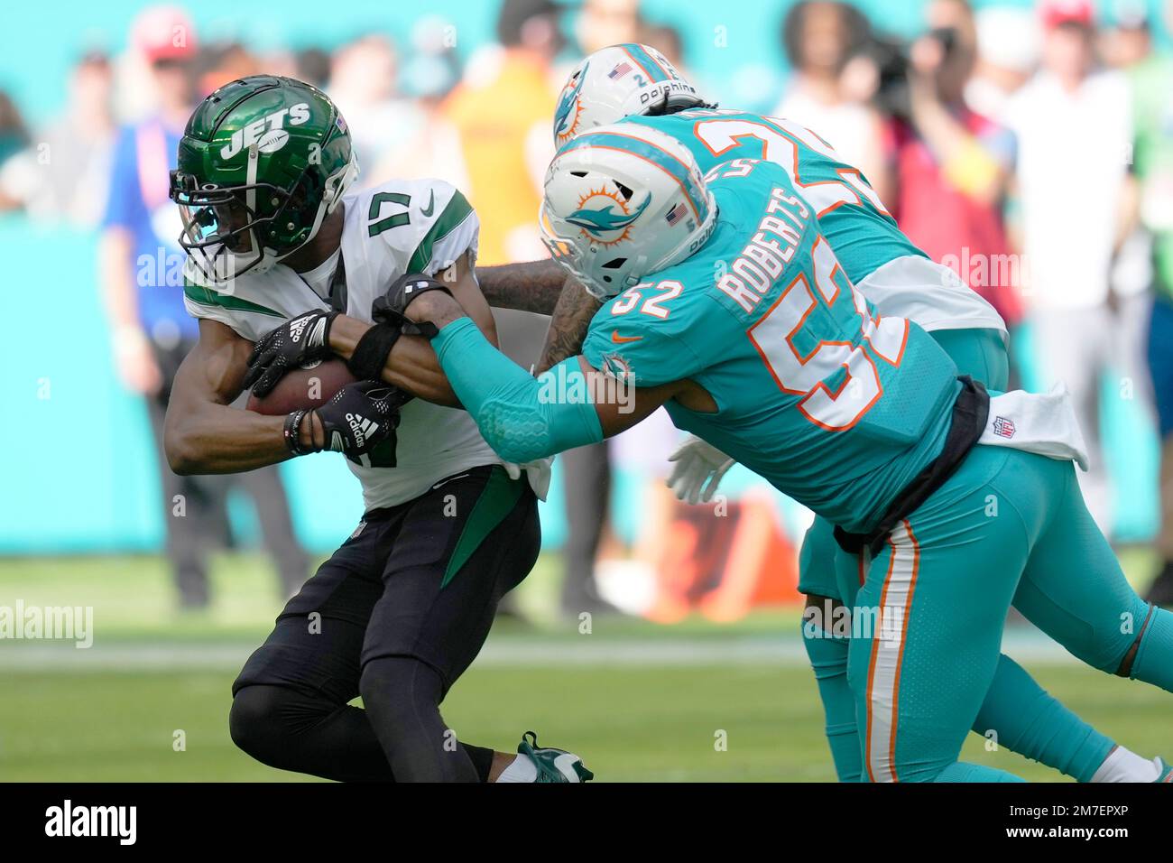 Miami Dolphins linebacker Elandon Roberts (52) grabs New York Jets wide  receiver Garrett Wilson (17) during the first half of an NFL football game,  Sunday, Jan. 8, 2023, in Miami Gardens, Fla. (