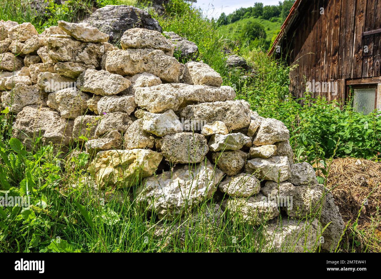Structure of a stone wall exemplified by one in the front yard of a cottage on the Swabian Alb near Bad Urach, Baden-Wurttemberg, Germany. Stock Photo