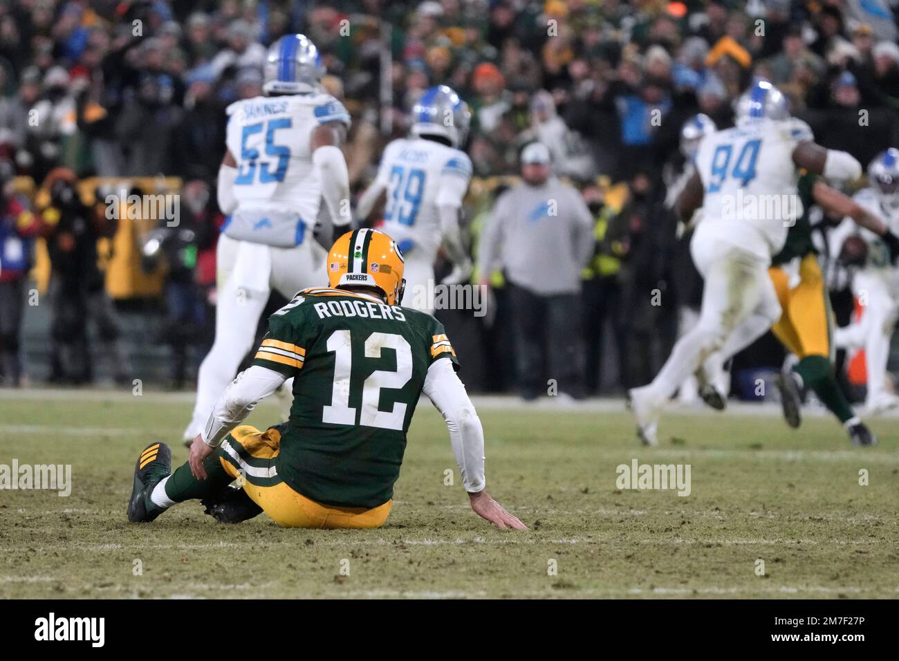 Green Bay Packers quarterback Aaron Rodgers sits on the turf after throwing an interception