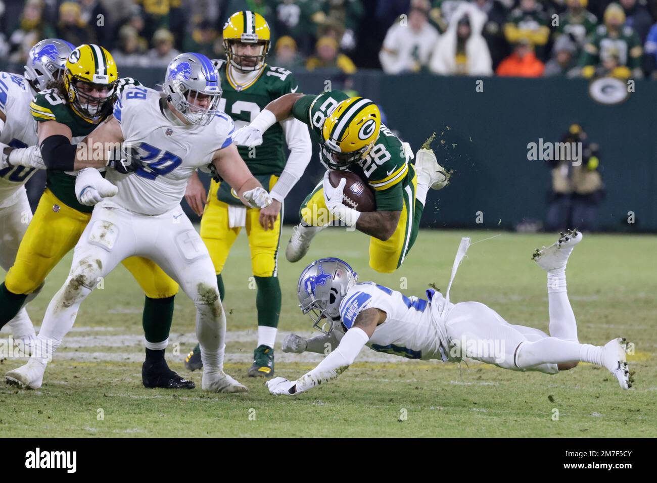 Green Bay Packers running back AJ Dillon (28) is upended by Detroit Lions cornerback Mike Hughes