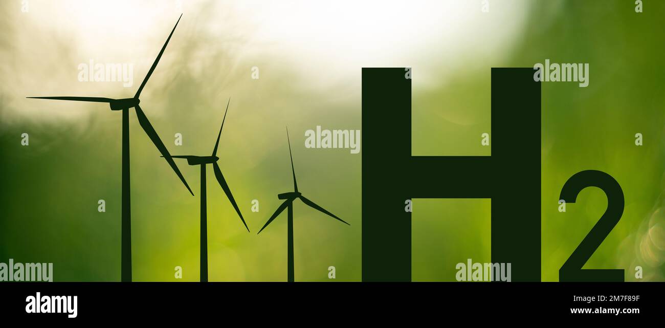 Silhouettes of Hydrogen symbol and wind turbines. Getting green hydrogen from renewable energy sources Stock Photo