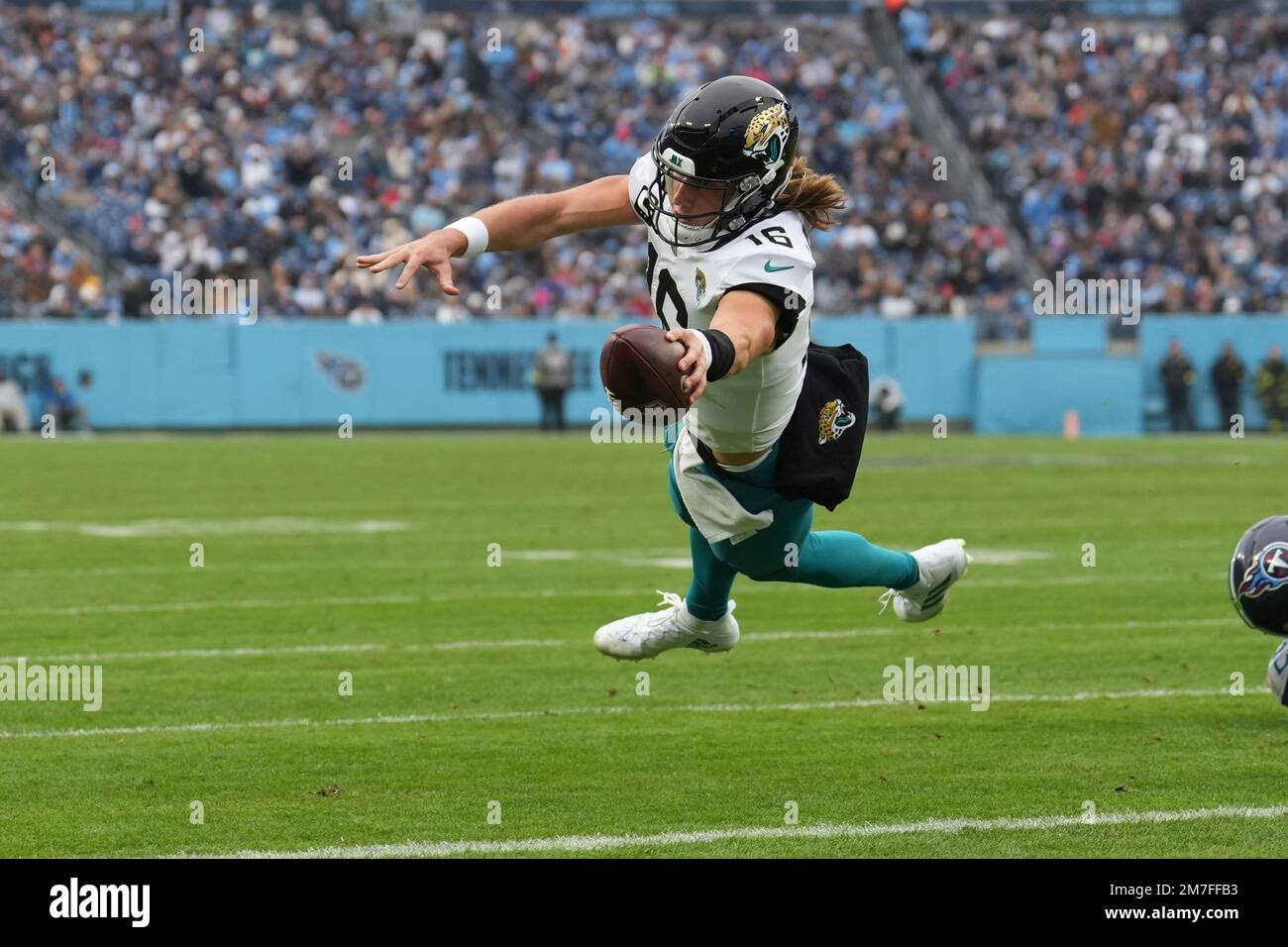 Jacksonville Jaguars quarterback Trevor Lawrence (16) dives and reaches