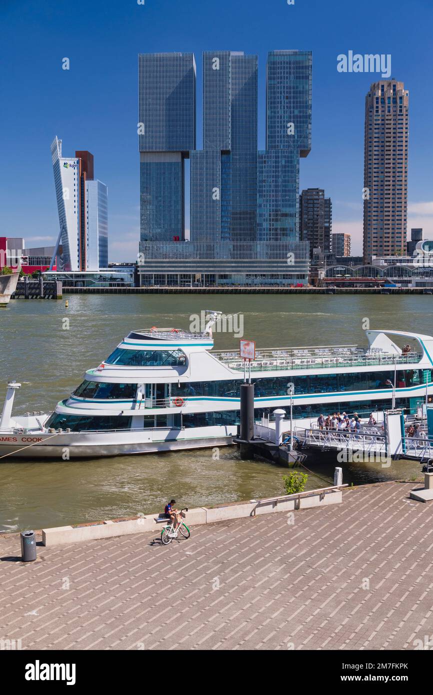 Holland, Rotterdam, The Nieuwe Maas River with the De Rotterdam Building in the centre flanked by the KPN Telecom Tower building on the left and the New Orleans Tower on the right with tourists disembarking from a river tourist boat in the foreground. Stock Photo