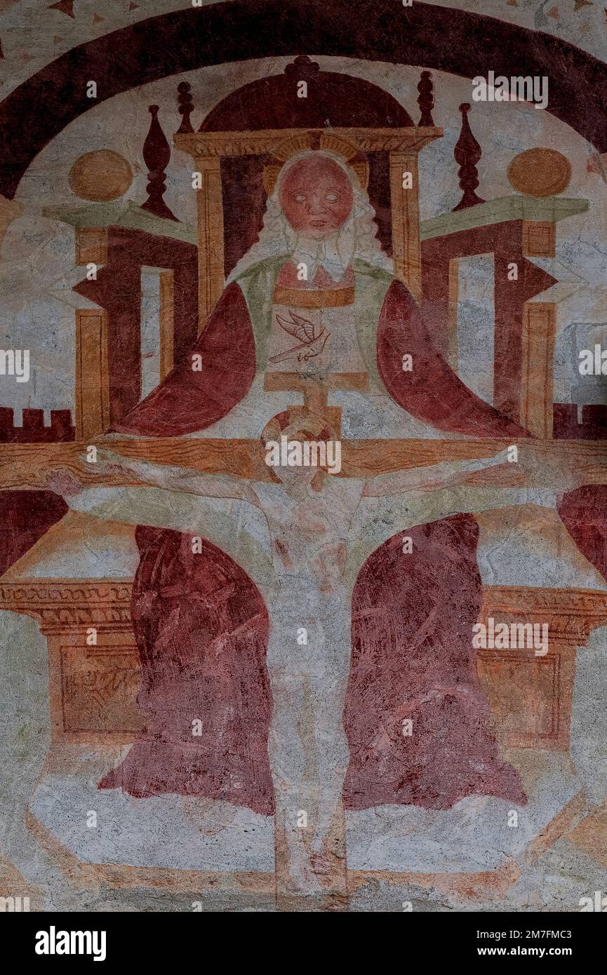 The Holy Trinity, with God the Father enthroned, the crucified Christ and the dove of the Holy Spirit: late 1400s Renaissance fresco by the Lombardic itinerant artist Cristoforo I Baschenis on the west front of the Chiesa di Sant’Antonio Abate or Church of St Anthony the Abbot at Pelugo, Trentino-Alto Adige, Italy. Stock Photo