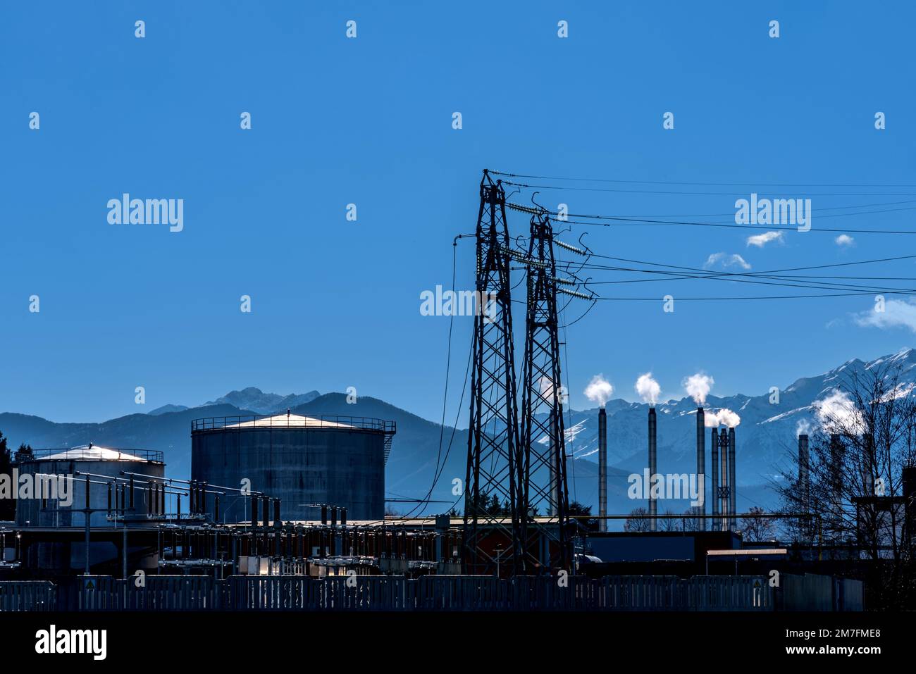 Electricity production landscape with smoking chimneys, with Oil fuel