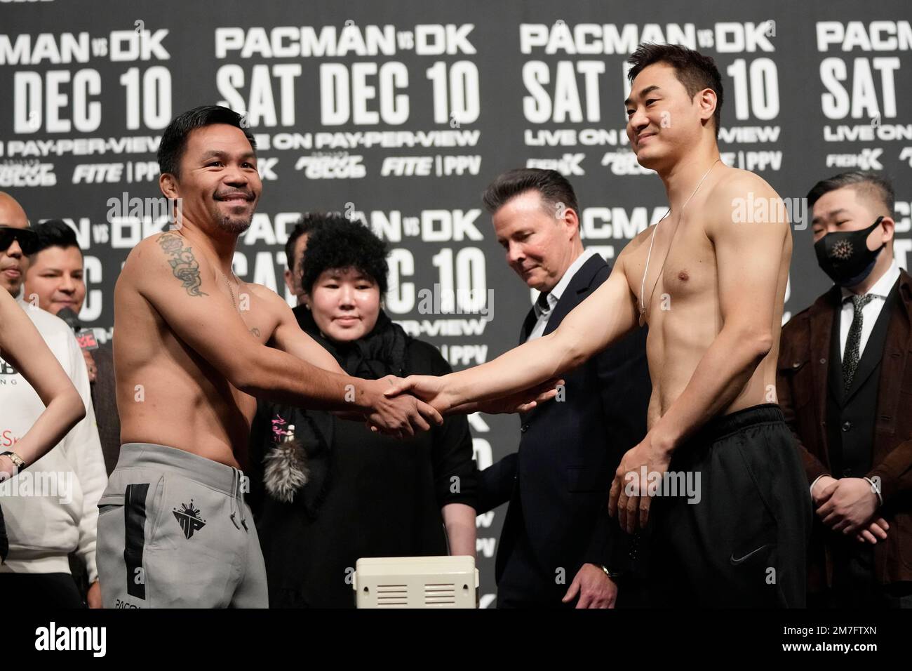 Former Filipino boxer Manny Pacquiao, left, shakes hands with South Korean martial artist D.K. Yoo during a weigh-in at the KINTEX in Goyang, South Korea, Saturday, Dec