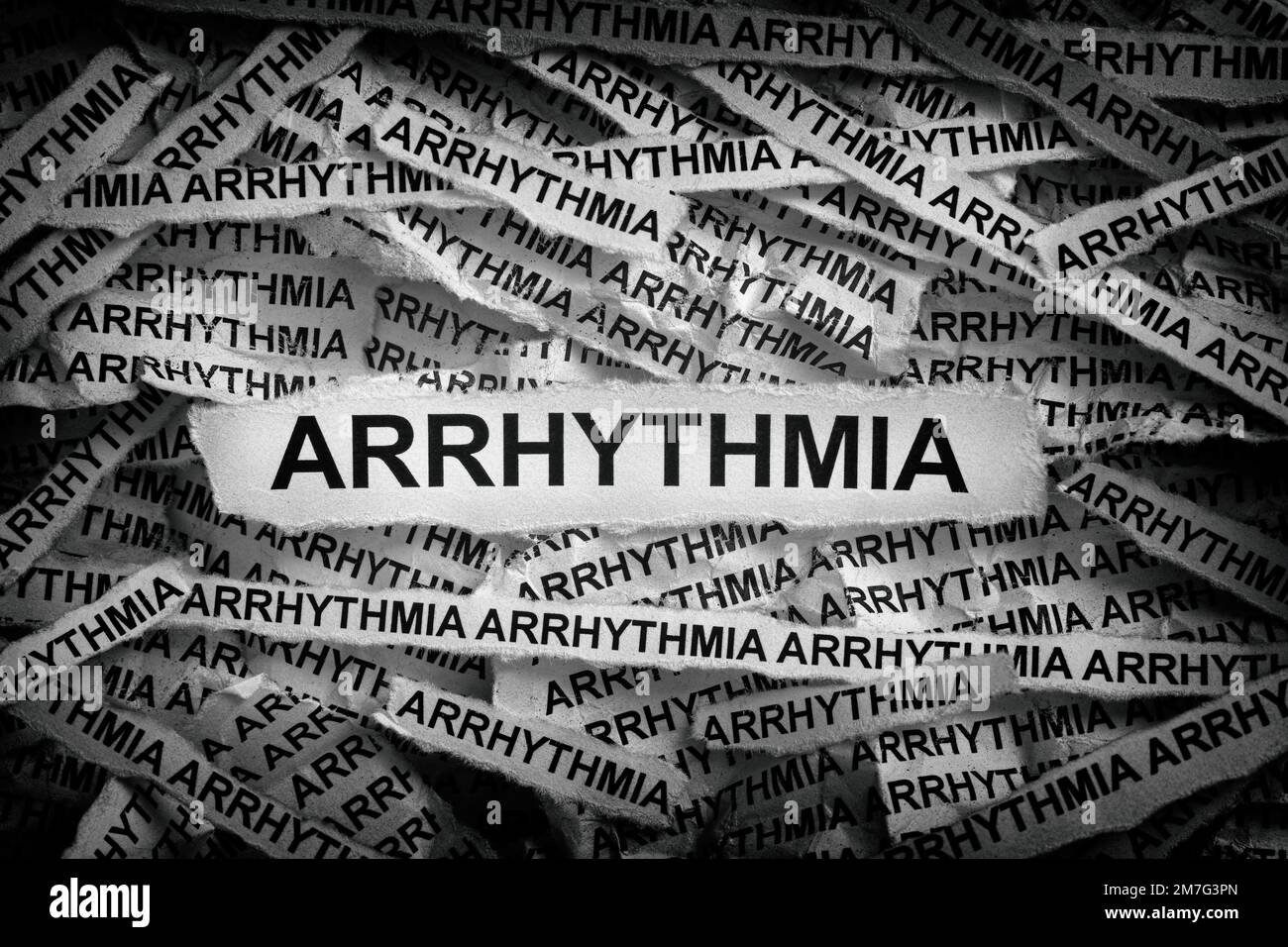 Strips of newspaper with the words Arrhythmia typed on them. Black and white. Close up. Stock Photo