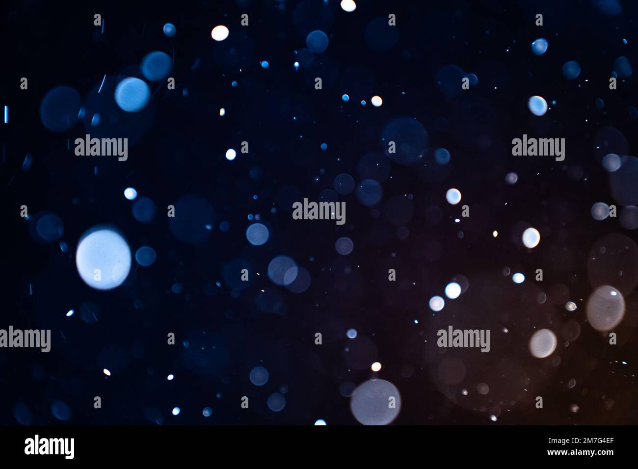 Closeup of dust particles on black background bokeh blur overlay effect with copy space for text
