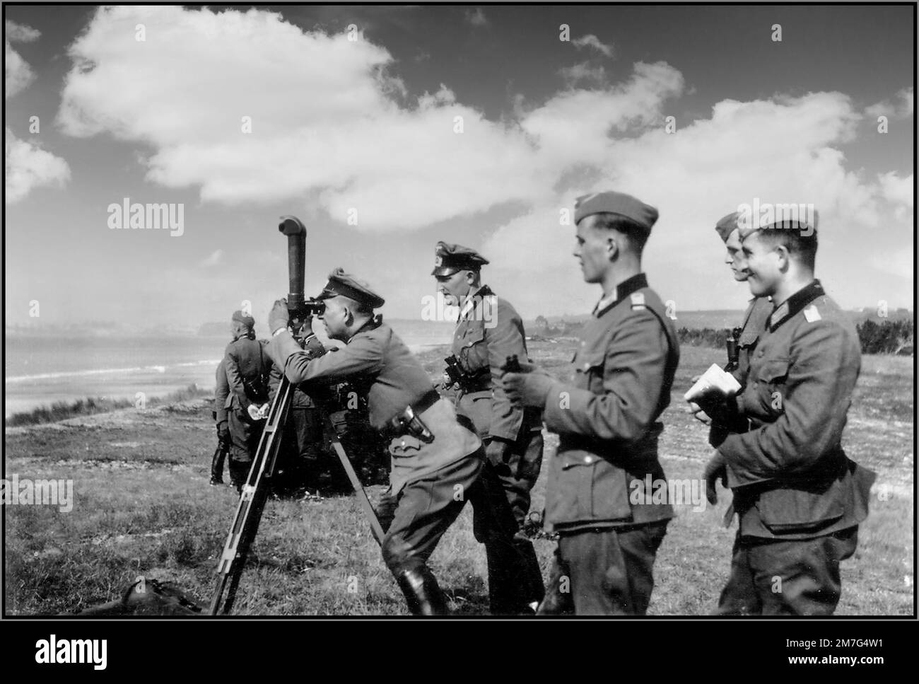 D-DAY INVASION German Wehrmacht Army officers survey the Normandy beaches near French towns of Granville and Saint-Pair-sur-Mer shortly before the Allied invasions in 1944 Nazi Wehrmacht army soldiers and officers surveying the coast using trench binoculars to appraise enemy invasion ahead. 1940s World War II Stock Photo