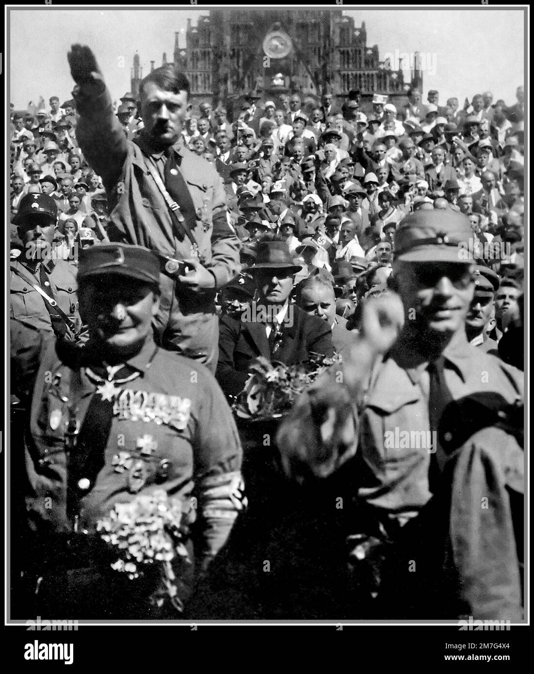 Adolf Hitler 1930s at a Nuremberg Nazi Germany rally with Hermann Goring in foreground. A stern Adolf Hitler in SA uniform giving a Heil Hitler salute Stock Photo