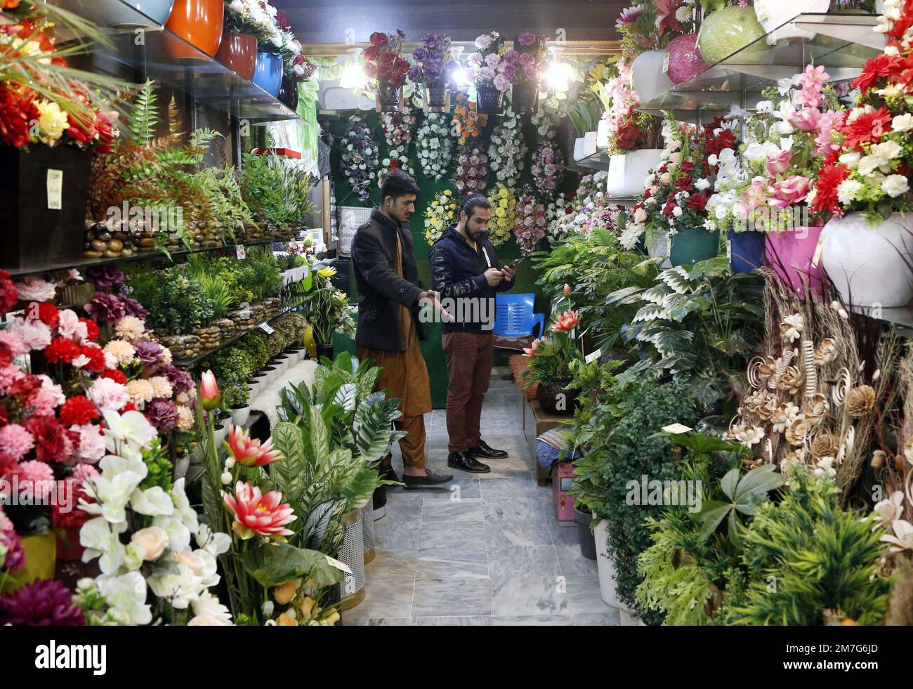 Rawalpindi. 3rd Jan, 2023. People visit a flower shop selling artificial flowers imported from