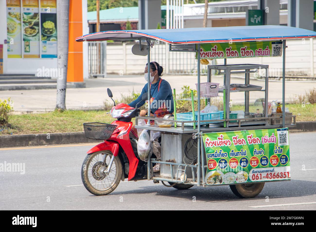 RATCHABURI, THAILAND, NOV 16 2022, A woman rides a motorcycle with a