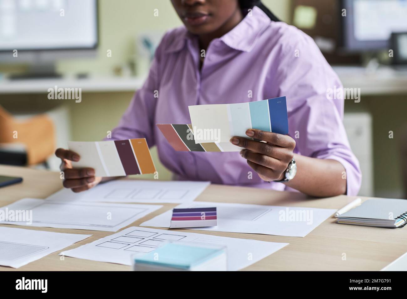 Close up of black young woman as creative designer holding color swatches in office, copy space Stock Photo