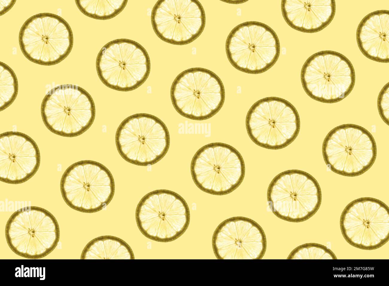 Pattern made of backlit lemon slices on yellow background Stock Photo